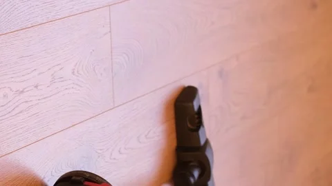 Cleaning at home with a hand vacuum cleaner. Vertical video Stock Footage 250354524