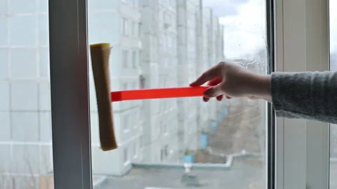 Cleaning a home window with a squeegee close up ProRes 4K Stock Footage 168768140