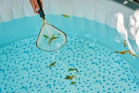 Cleaning inflatable pool with net Stock Photos