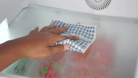 Cleaning the inside of a freezer with a cloth Stock Footage 345102138