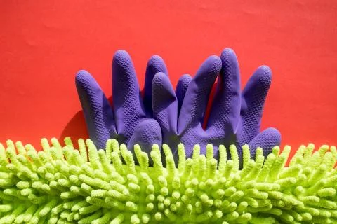 Cleaning kit isolated on red background. Set of napkins, rubber gloves and Stock Photos