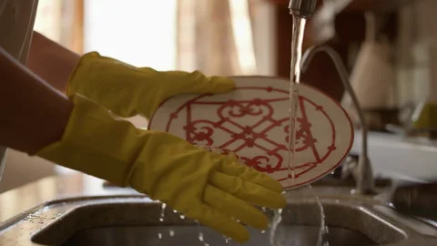 Cleaning in the kitchen. Closeup of female hands wash a plate in the kitchen Stock-Footage 129397451