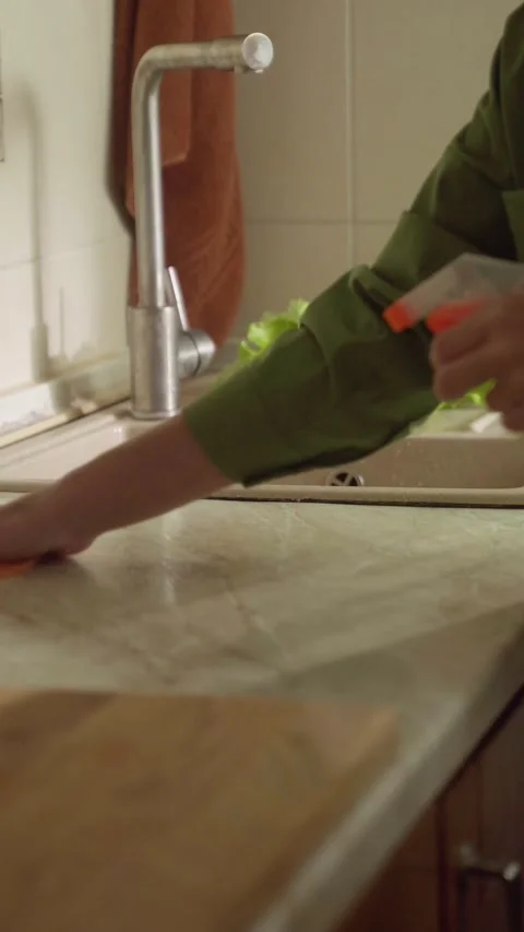 Cleaning a kitchen countertop while preparing for a meal with fresh ingredients 스톡 동영상 294916210
