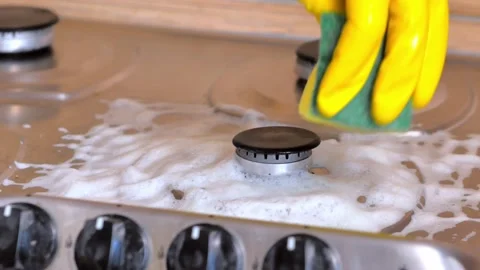 Cleaning the kitchen with an effective cleaner. A hand in a yellow rubber glove  Stock Footage 190867439