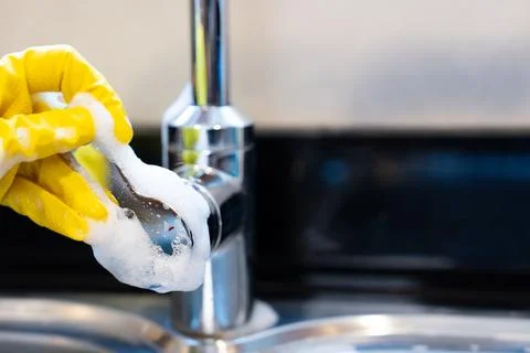 Cleaning kitchen faucet handle Stock Photos