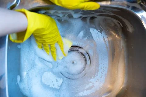 Cleaning kitchen sink with sponge Stock Photos