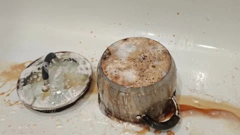 Cleaning kitchen utensils from grease and burnt food in a sink Stock Footage 340461669