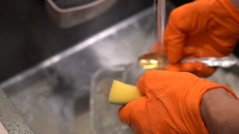 Cleaning Kitchen Utensils: A Step-by-Step Process of Washing with a Sponge Under Stock Footage 321051071