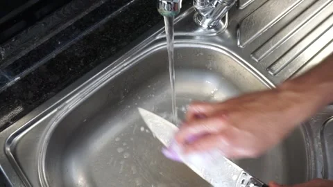 Cleaning the knife with water and detergent. Stock Footage 257514101