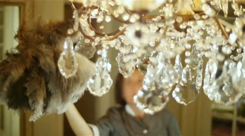 Cleaning lady dusting chandelier with feather duster Stock Footage 41457084