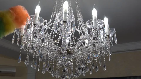 Cleaning lady dusting chandelier with feather duster Stock Footage 102320141