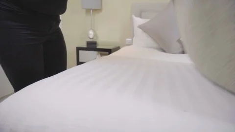 Cleaning lady making bed and tucking sheets Stock Footage 91031524