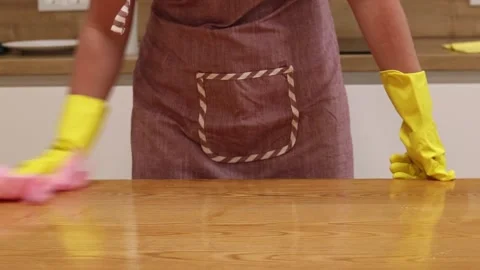 Cleaning lady wipes kitchen table. Woman in apron and yellow gloves Stock Footage 317260635