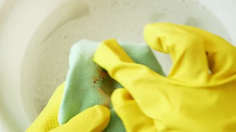 Cleaning laundry manually. Women's hands in gloves washing dirty stained on c Stock Footage 165322545