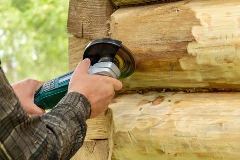Cleaning the log with a grinding machine. preparation for painting Stock Photos