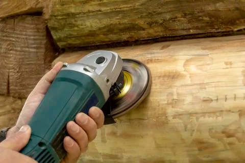 Cleaning the log with a grinding machine. preparation for painting Stock Photos