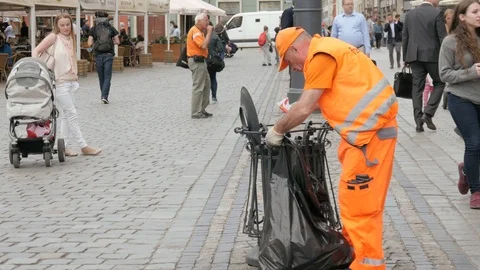 Cleaning Man picks up a Garbage Bin on the Street in the City, Wroclaw, Poland Stock Footage 89837107