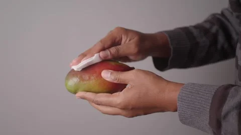 Cleaning a mango before slicing it for a snack Stock Footage 329011452