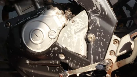 Cleaning a motorcycle engine and body with a soapy sponge Stock Footage 345549269
