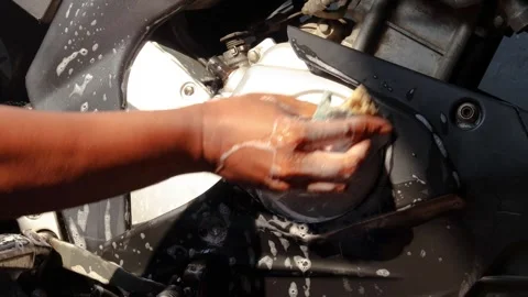 Cleaning a motorcycle engine and body with a soapy sponge Stock Footage 345549366