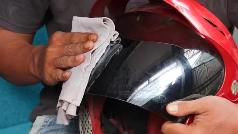 Cleaning a motorcycle helmet visor Stock Footage 340265119