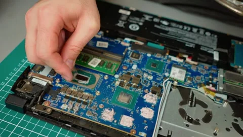 Cleaning old thermal paste from processor chip in laptop motherboard. Removing Stock Footage 309327462