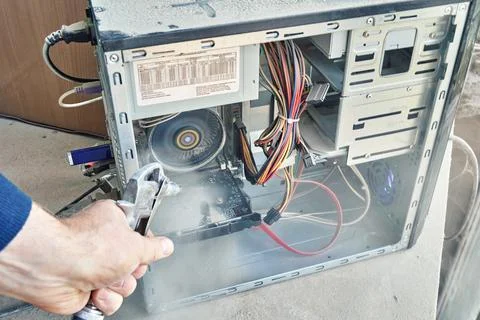 Cleaning an open dusty old computer with a compressed air gun Stock Photos