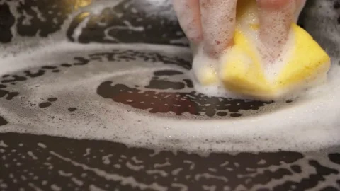 Cleaning the pan with a sponge and detergent Stock Footage 169769799