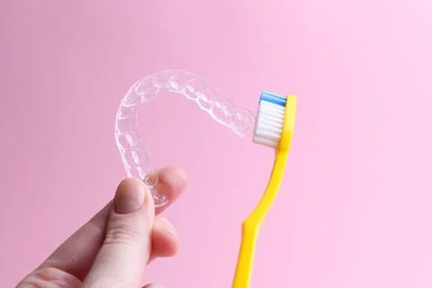 Cleaning plastic aligner aligners with a toothbrush Foto stock