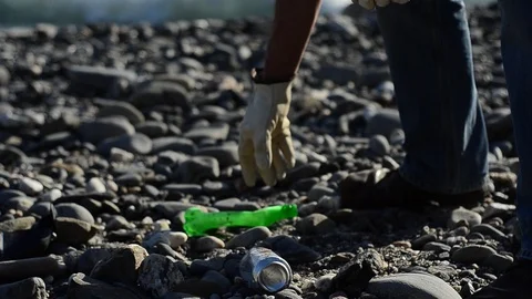 Cleaning up plastic off a beach, with ocean in the background. Volunteer concept Stock Footage