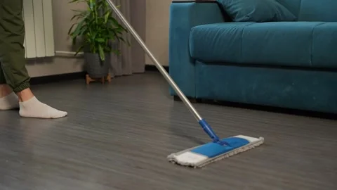 Cleaning with precision, she wipes away dust with a mop. Peaceful house cleaning Видео 308020118