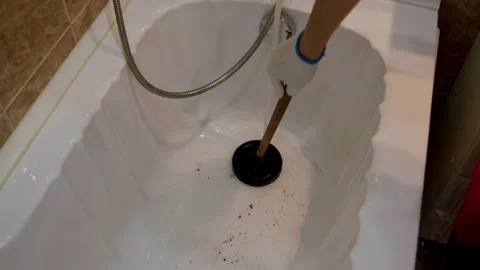 Cleaning process in a bathtub begins with visible debris, followed by the use of Stock Footage 326053448