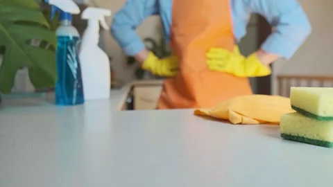 Cleaning products on the kitchen table with a cleaning specialist in the backgro Stock Footage 301868136