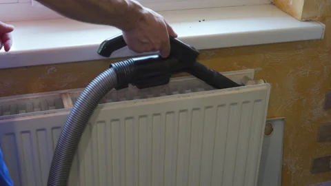 Cleaning radiator with a vacuum cleaner using a crevice tool attachment Vídeo Stock 347081531
