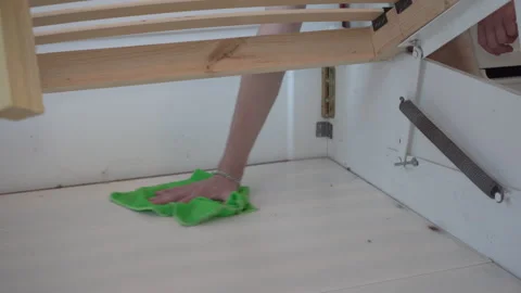 Cleaning with a rag inside the bed frame Stock Footage 336743787
