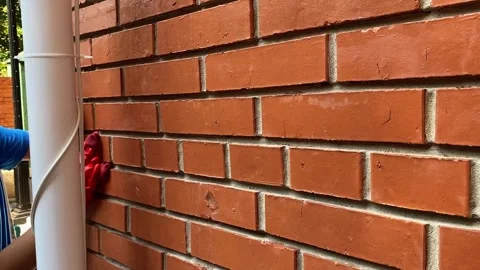 Cleaning a red brick wall from white outlets, a cleaning company is cleaning 库存影片 264343448