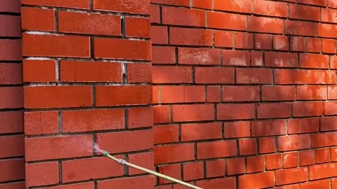 Cleaning a red brick wall from white outlets, a cleaning company is cleaning 库存影片 264343567