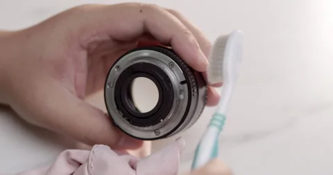 Cleaning the rim of a camera lens using an old toothbrush and a soft Stock Footage 277252067
