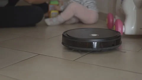 Cleaning robot does housework meanwhile mother plays with her child Stock Footage 143651999