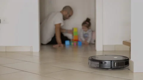 Cleaning robot does housework meanwhile father plays with his child Stock Footage 143653374