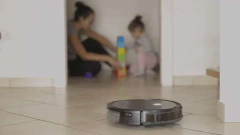 Cleaning robot does housework meanwhile mother plays with her child Stock Footage 143654550