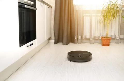 Cleaning the room with an automatic robot vacuum cleaner and remote control v Stock Photos
