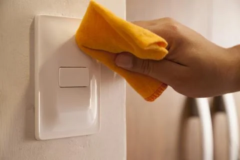 Cleaning the room light switch.. Stock Photos