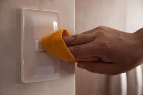 Cleaning the room light switch.. Stock Photos