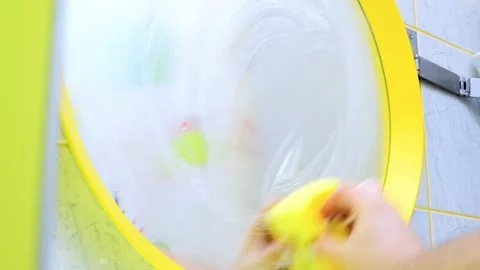 Cleaning round mirror with the rag in bathroom Stock Footage 170454238