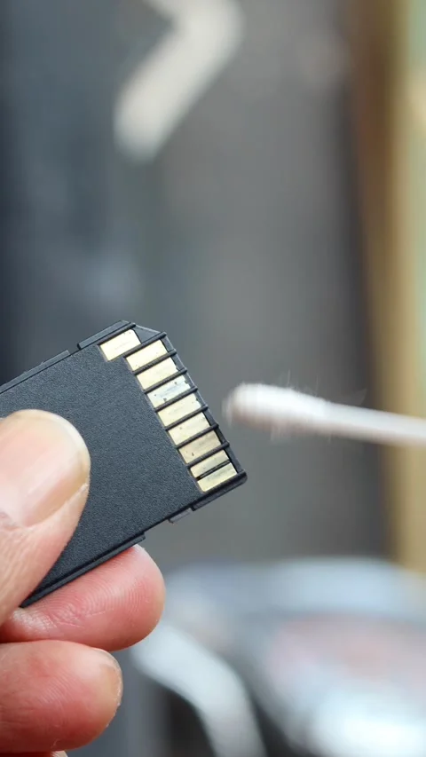 Cleaning SD memory card contacts using a cotton swab Stock Footage 345650659