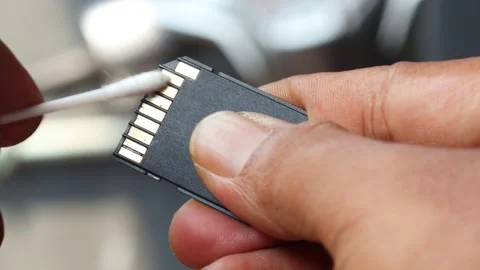 Cleaning SD memory card contacts using a cotton swab Stock Footage 345650675