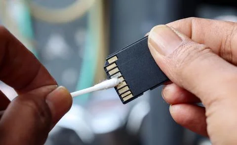 Cleaning SD memory card contacts using a cotton swab Foto stock