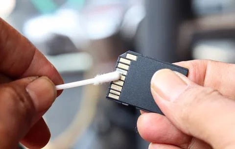 Cleaning SD memory card contacts using a cotton swab Foto stock