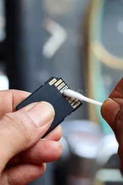 Cleaning SD memory card contacts using a cotton swab Foto stock